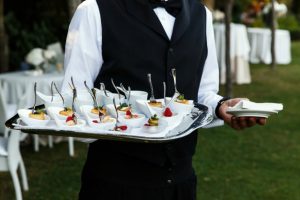Server holding a tray of appetizers