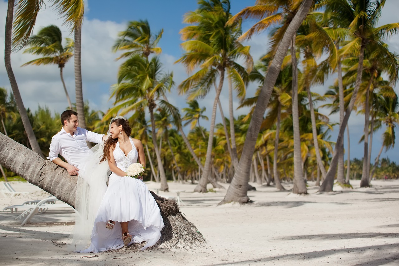 A bride and groom having a wedding photoshoot at the beach