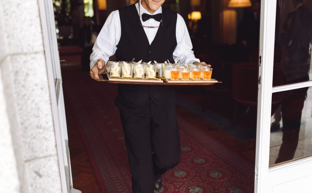 A professional caterer carrying a tray of food
