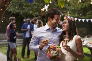 Young Couple Celebrating Wedding With Party In Backyard